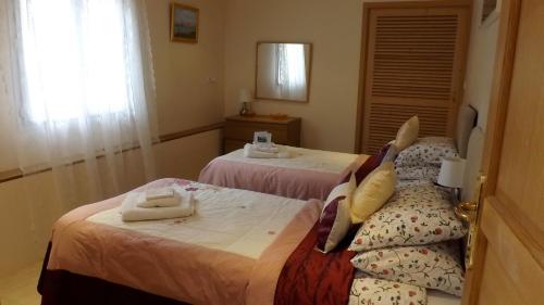 two beds in a hotel room with towels on them at Maison Du Ruisseau in Malaville