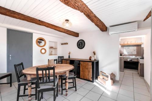 une cuisine et une salle à manger avec une table et des chaises en bois dans l'établissement Maison de campagne 6 personnes, à Saint-Julien