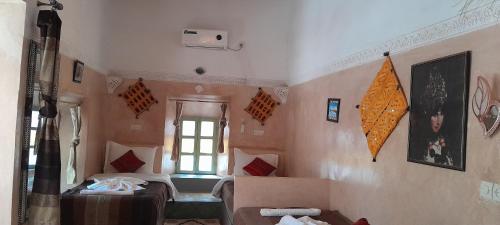 a room with two beds and a window at Riad Dades Birds in Boumalne