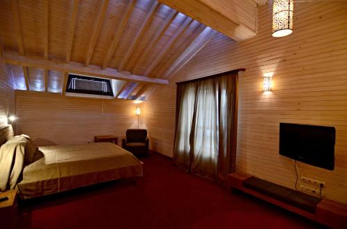 a bedroom with a bed and a flat screen tv at Villa Vuchev in Velingrad