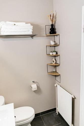 La salle de bains est pourvue de toilettes et d'une étagère avec des serviettes. dans l'établissement Welcome to Cristina's House, à Paris