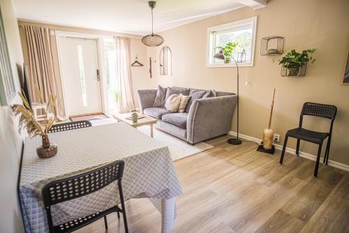 a living room with a table and a couch at Hallonet in Alingsås
