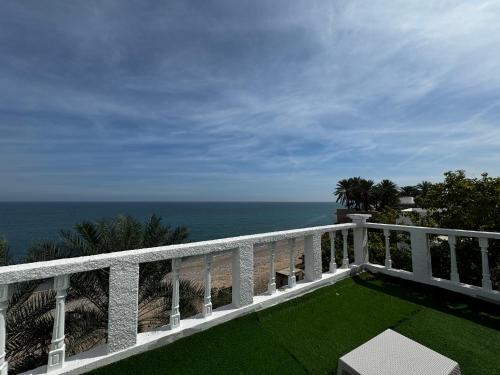 a white balcony with a view of the ocean at Wadi shab Beach Resort in Sur