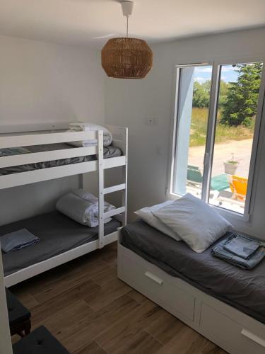une chambre avec deux lits superposés et une fenêtre dans l'établissement Le Domaine de Saint-Michel Maison de vacances 2 à 8 personnes, à Commequiers