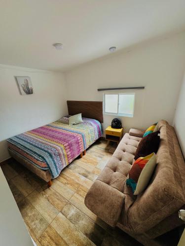 a living room with a couch and a bed at Apartahotel Arcoiris Salento in Salento