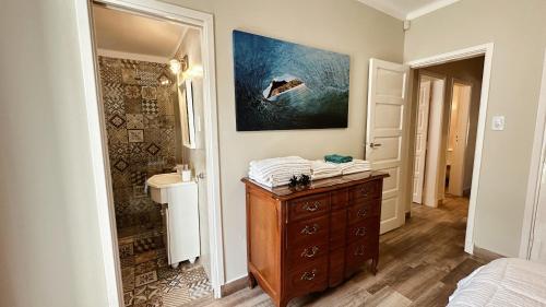 a bathroom with a wooden dresser and a painting on the wall at Casa Miriam - Casa En Miramar Para 4 PAX Con Cochera - Hola Sur in Miramar