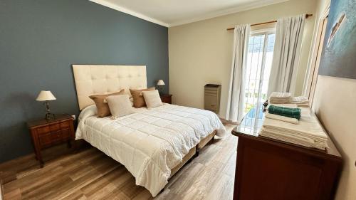 a bedroom with a large bed and a window at Casa Miriam - Casa En Miramar Para 4 PAX Con Cochera - Hola Sur in Miramar