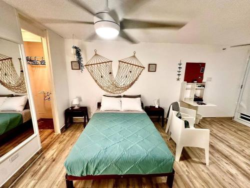um quarto com uma cama e uma ventoinha de tecto em Relaxing Studio Near El Yunque With Pool View em Luquillo