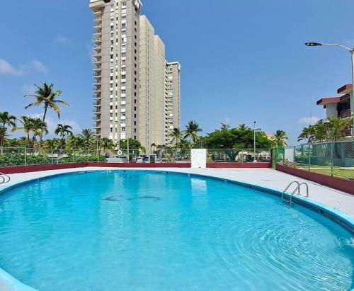 uma grande piscina em frente a um edifício alto em Relaxing Studio Near El Yunque With Pool View em Luquillo