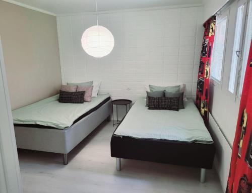 Habitación con 2 camas y luz colgante en Tilava uudistettu perheasunto, en Rovaniemi