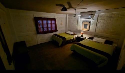 a hotel room with two beds and a window at Jaco Mizata Beach and River in Las Piedras