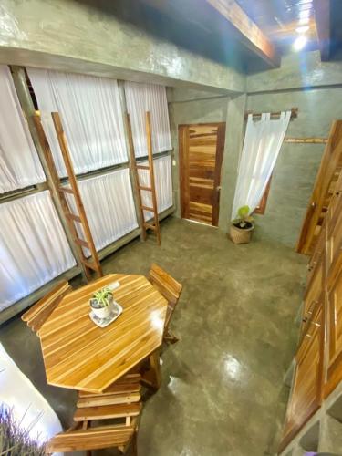 a room with a wooden table and some windows at Hermanos Perdidos Surf in Las Tunas