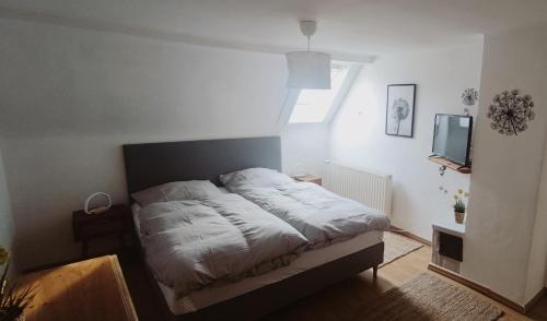 a small bedroom with a bed and a television at Haus Helga in Albersweiler