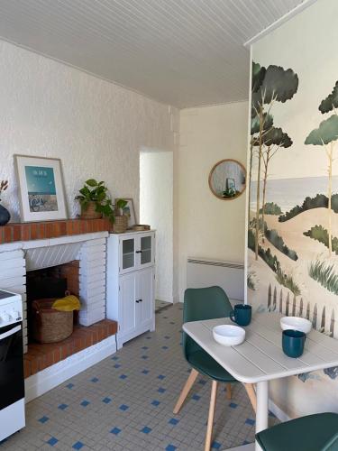 un salon avec une table et une cheminée dans l'établissement Côte&Marais, à Jard-sur-Mer