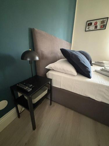 a bedroom with a bed with pillows and a table at Appartamento Giulietta in Nizza Monferrato