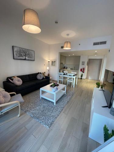 a living room with a couch and a table at F1 - Daisy Hill 1BR Waters Edge Canal View Yas island - Theme Parks in Abu Dhabi