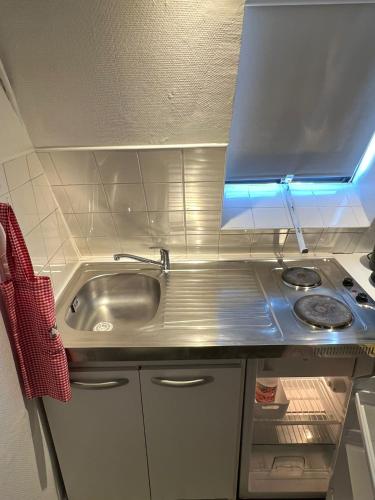 une petite cuisine avec un évier et une cuisinière dans l'établissement Apartamento Torre Eiffel- Trocadéro, à Paris