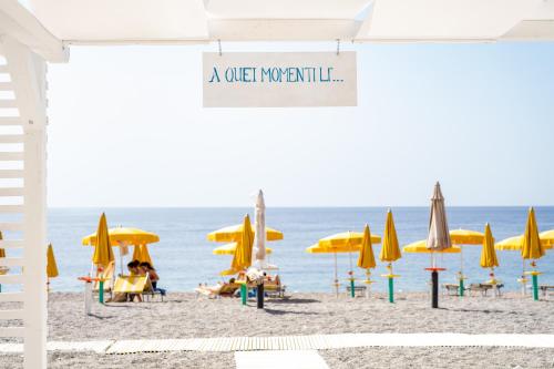 a beach with umbrellas and people sitting on the sand at Hotel Palace in Catanzaro Lido