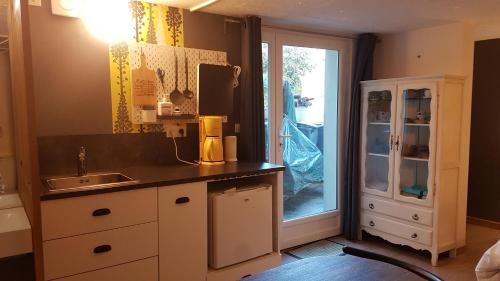 une cuisine avec un comptoir, un évier et une fenêtre dans l'établissement Chambre indépendante avec cuisinette, à Cesson-Sévigné