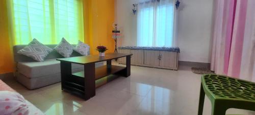 a living room with a couch and a coffee table at Selfie n Studio Homestay in Khānāpāra