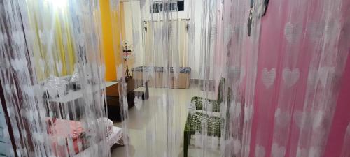 a bathroom with curtains on the wall and a mirror at Selfie n Studio Homestay in Khānāpāra