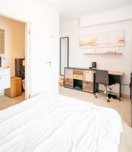 a bedroom with a white bed and a desk at Studio cosy a 5mn du Kirchberg in Senningerberg