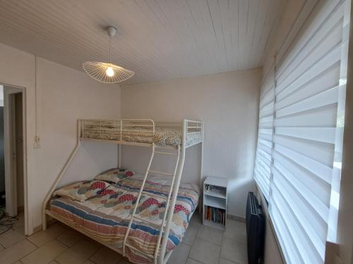 une chambre avec un lit superposé dans une pièce dans l'établissement Cottage au cœur des Landes, à Lit-et-Mixe