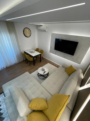 a living room with a couch and a tv at Delux apartman President Centar II in Brčko