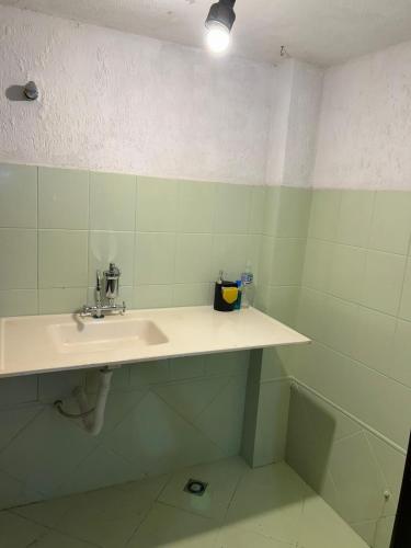 a bathroom with a white sink in a room at Apartamento no Centro de Londrina in Londrina