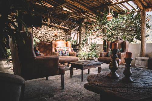 a living room with leather chairs and a table at Las Cumbre Hotel & Spa Termal in Quetzaltenango