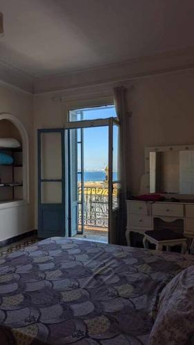 a bedroom with a bed and a door to a balcony at Appartement au cœur d'Alger in Kasbah