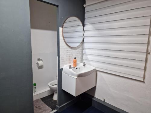 a bathroom with a white sink and a mirror at Room near East Midland Airport 6 in Kegworth
