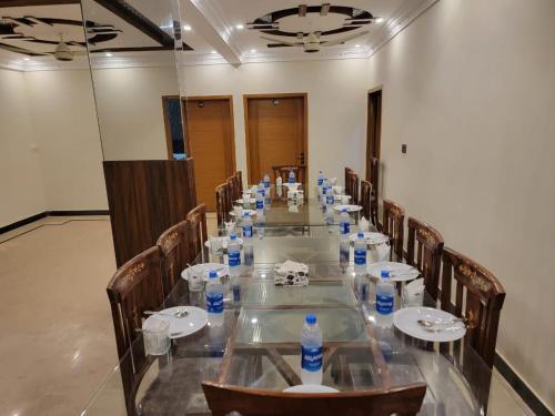 a long table with chairs and bottles of water on it at Airport Guest House - JIA in Karachi