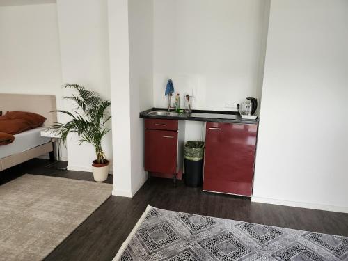 a room with a kitchen with a counter and a table at TheSuites Frankfurt-Airport - Studio Room - Private WC, Shared Bathroom in Hofheim am Taunus