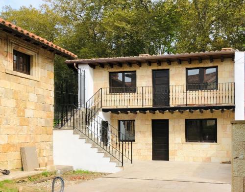 a brick building with a balcony and a staircase at La Casita 3 dormitorios in Santillana del Mar