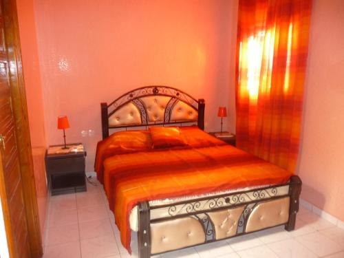 ein Schlafzimmer mit einem großen Bett mit einer orangefarbenen Decke in der Unterkunft RYAD Pierre in Marrakesch