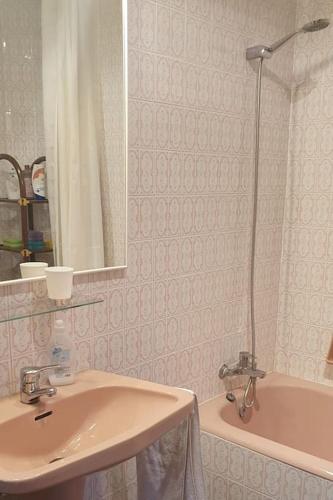a bathroom with a sink and a mirror and a tub at Casa Los Quinos in Bielsa