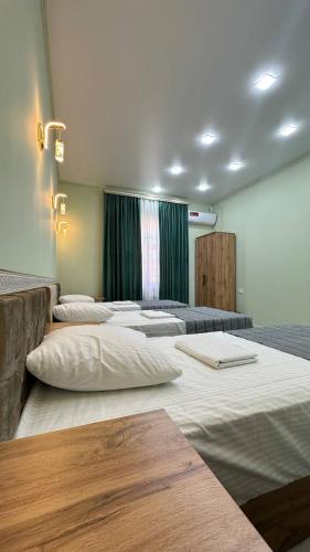 a room with four large beds in a room at Safo Guest House in Khiva