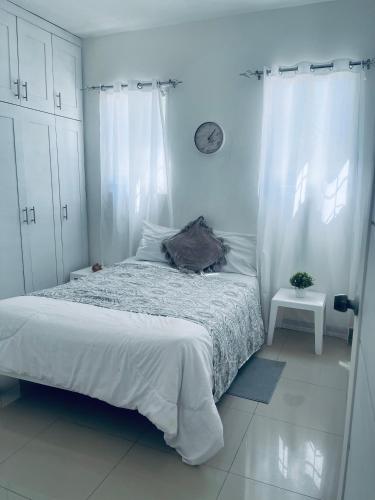 ein weißes Schlafzimmer mit Bett und weißen Vorhängen in der Unterkunft A Caribbean-style rebirth, 2 minutes from the beach in La Romana