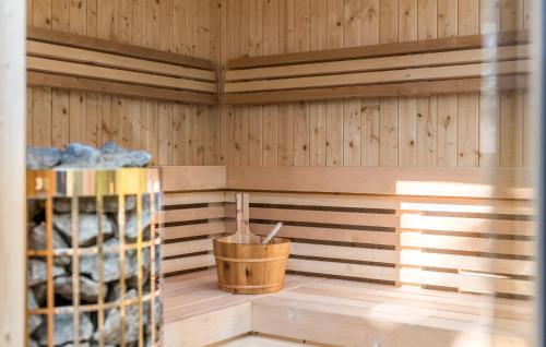a sauna with wood paneling and a bucket of wine bottles at Amazing Home In Grindsted With Sauna in Grindsted