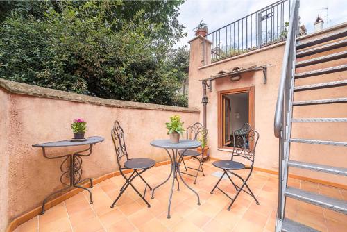 a patio with two tables and chairs and a fence at Domus Colonnato su Villa d'Este in Tivoli