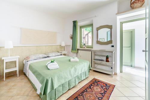 a bedroom with a green bed and a mirror at Domus Colonnato su Villa d'Este in Tivoli