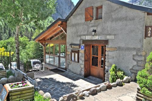 a stone house with a wooden door and a balcony at Camping Valle de Bujaruelo in Torla