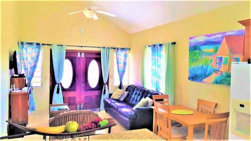 a living room with a purple couch and a table at Island Paradise in The Valley