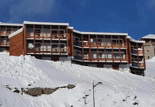 un bâtiment au sommet d'une colline enneigée dans l'établissement Studio 4 pers plein pied résidence Bero Bisto, face aux pistes, à Bagnères-de-Bigorre