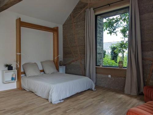 a bedroom with a bed and a large window at Hébergement indépendant centre bourg in Nozay