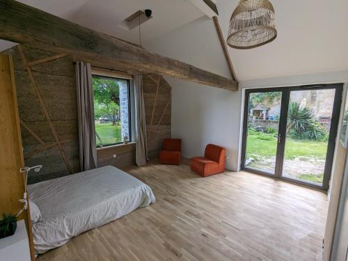 a bedroom with a bed and a large window at Hébergement indépendant centre bourg in Nozay