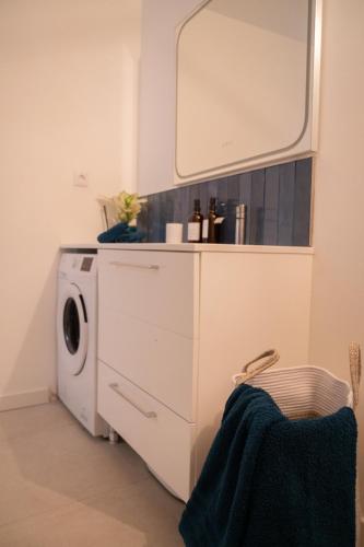 - une buanderie avec un lave-linge et un miroir dans l'établissement Loustalot - Appartement lumineux 3 chambres - Parking Gratuit, à Béziers