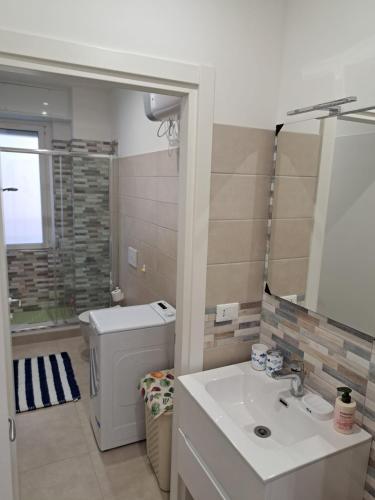 a bathroom with a sink and a washing machine at Casa di Leo in Loano