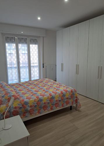 a bedroom with a bed with a colorful quilt at Casa di Leo in Loano